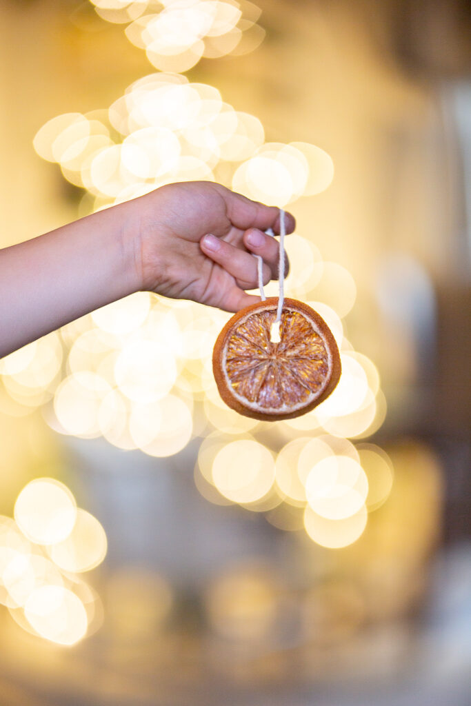 hand holding orange slice ornaments 
