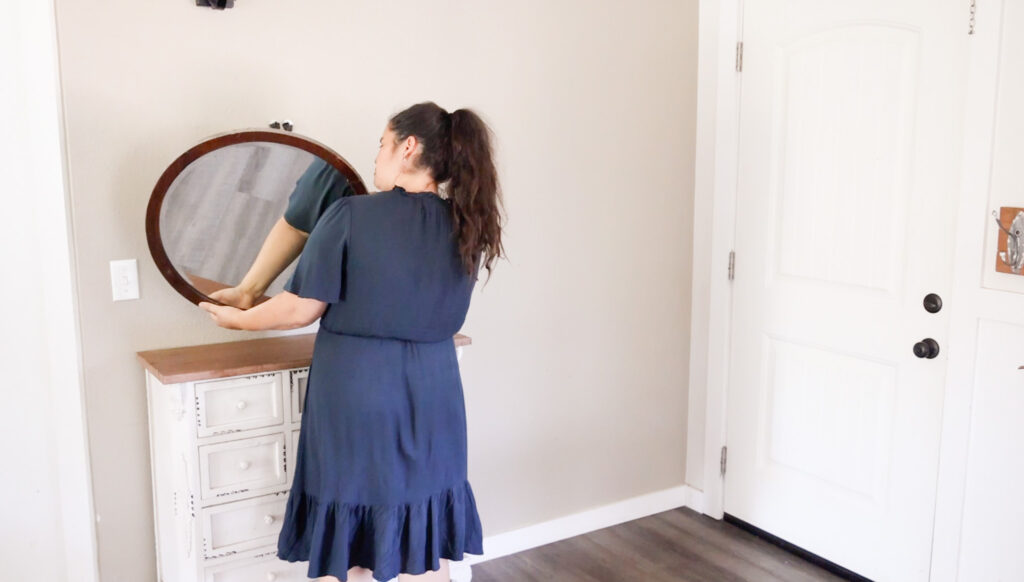 woman taking down mirror