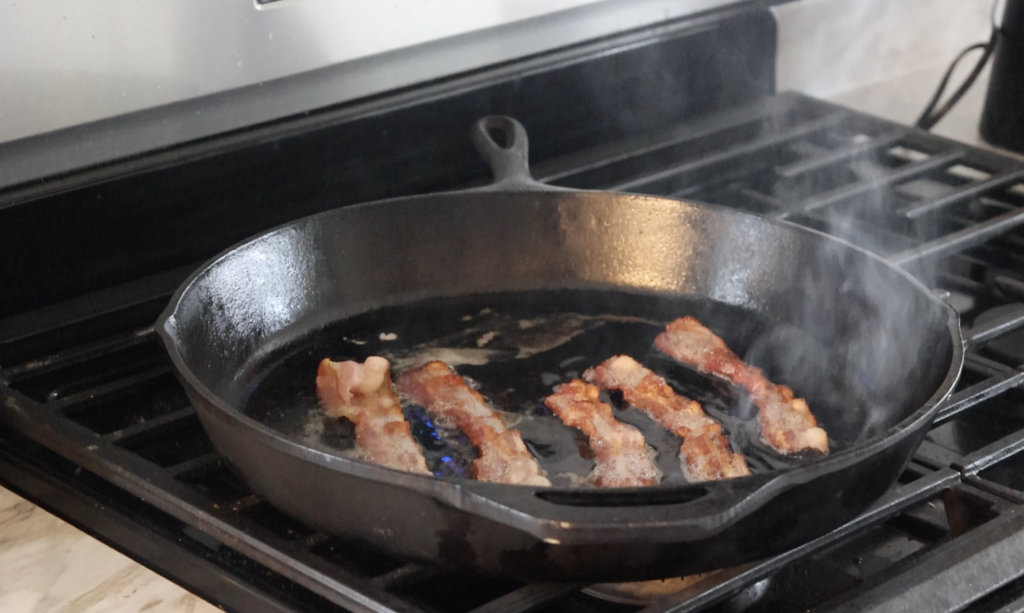 bacon cooking in cast iron skillet 