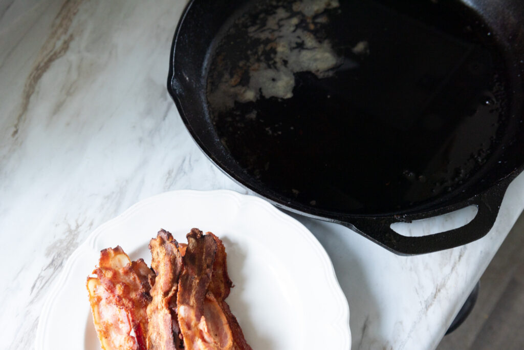 cast iron pan sitting next to bacon 